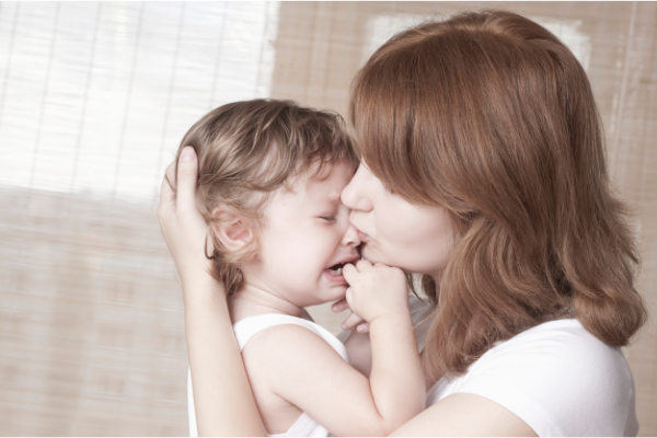 Mother consoling a crying child in her arms