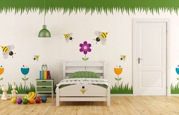 A child's bedroom with colorful garden-themed decals on the wall. There is a twin bed, a nightstand, and toys on the floor.