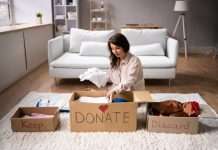 A woman sits on the floor in front of a white couch and sorts clothing into boxes labeled, "Keep," "DONATE," and "Discard."